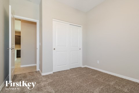 a bedroom with a closet and a door to a bathroom
