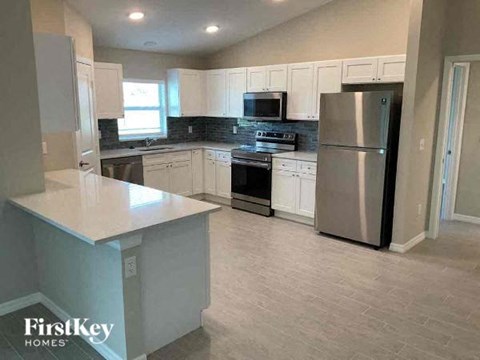 A kitchen with a refrigerator, stove, and microwave.