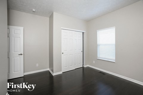 the living room of an empty house with a door and a window