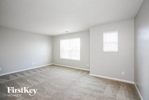 a spacious room with white walls and a tiled floor