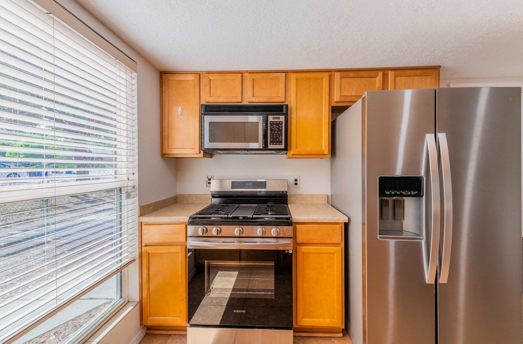 a kitchen with stainless steel appliances and wooden cabinets