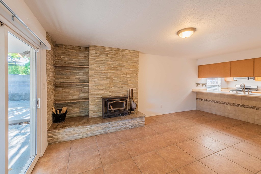 a living room with a fireplace and a kitchen