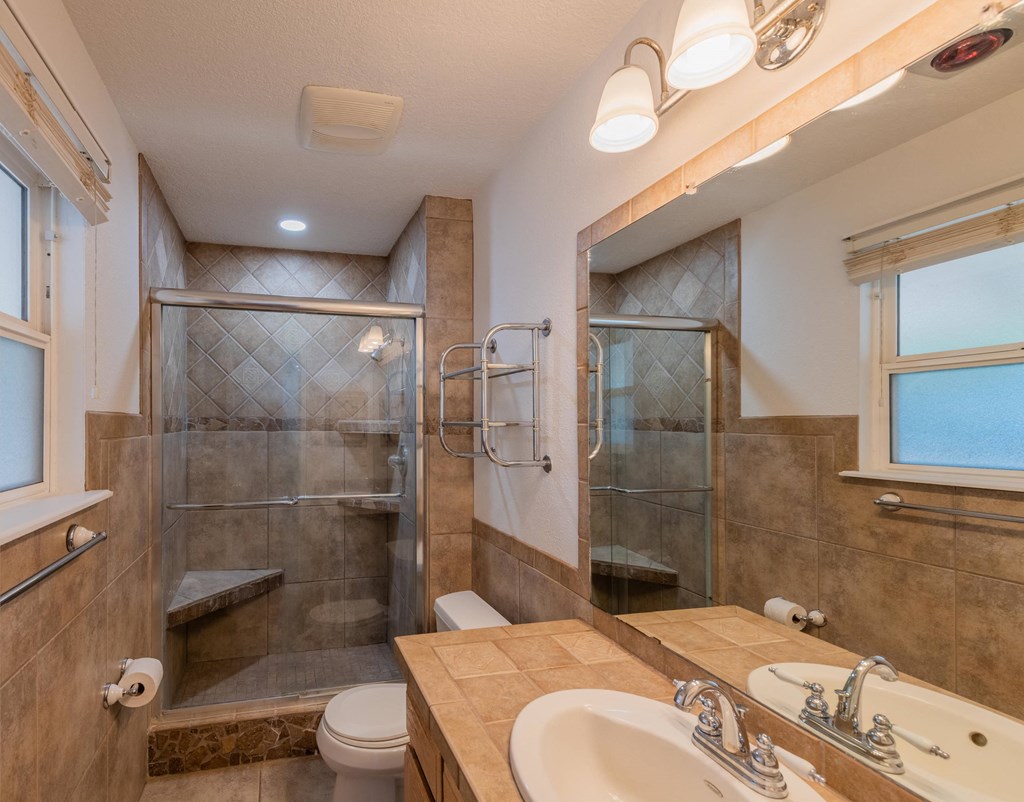 a bathroom with a shower and a sink and a toilet