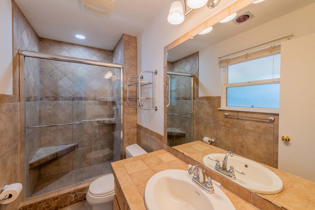 a bathroom with a shower and a sink and a toilet