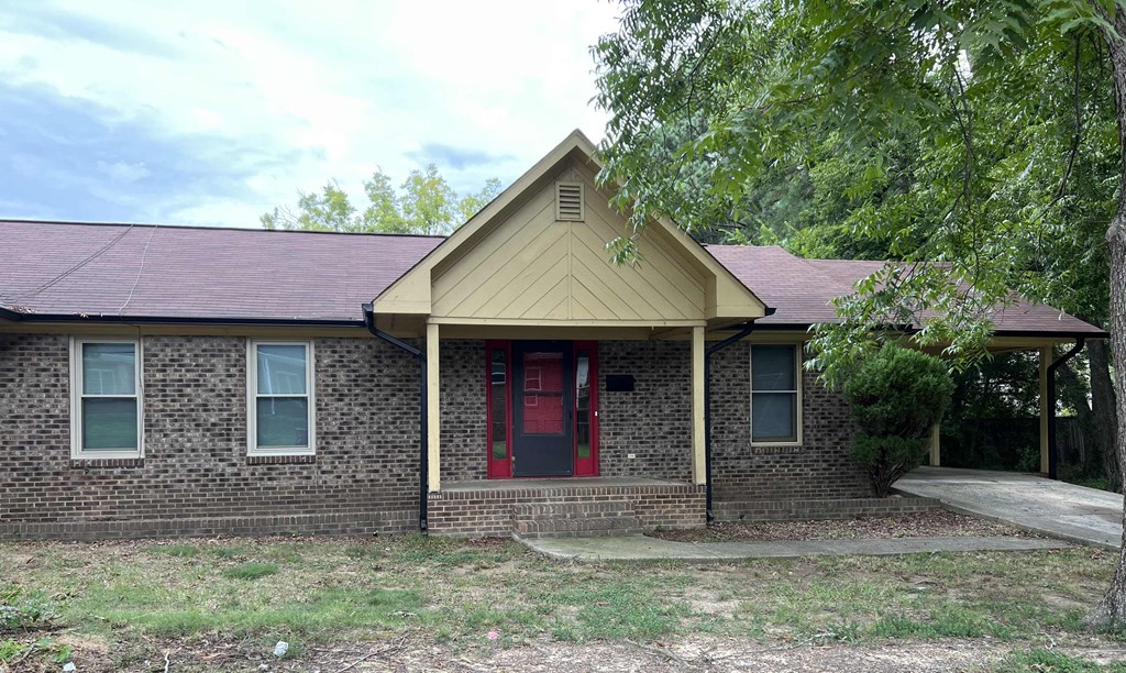 A house with a red door and a brick wall.