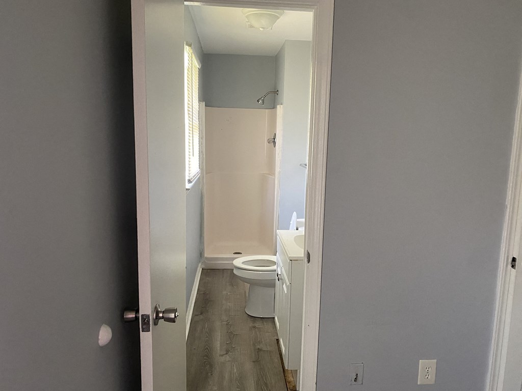 A bathroom with a toilet and a doorway.
