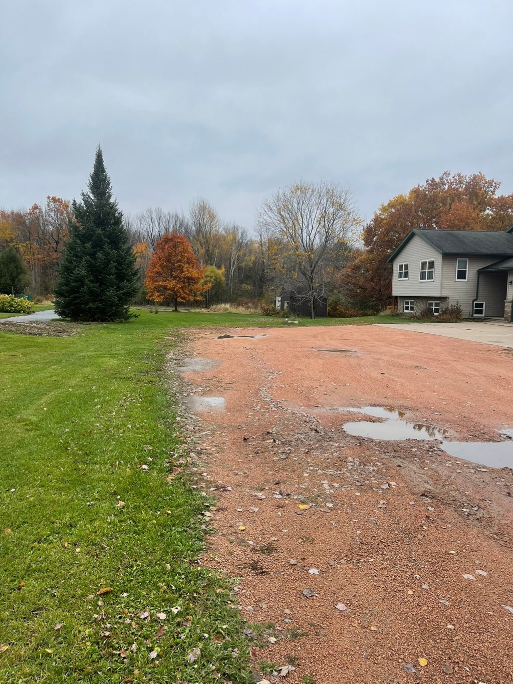 a dirt road with a house in the background