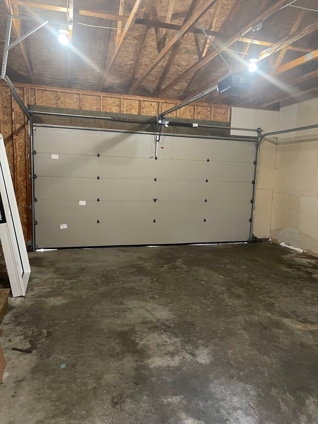 a garage with a white door and a concrete floor