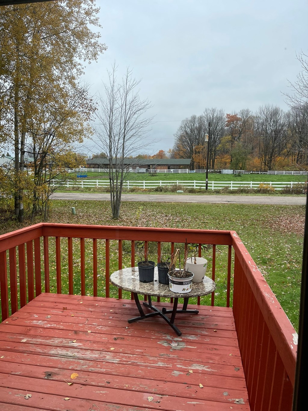 a deck with a table on it overlooking a field