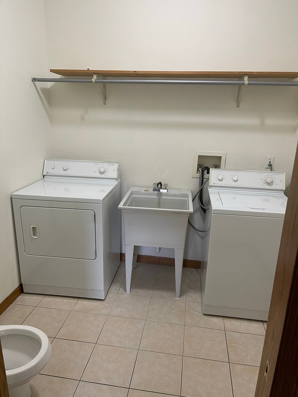 a laundry room with two washing machines and a sink