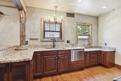 A kitchen with wooden cabinets and a marble countertop.