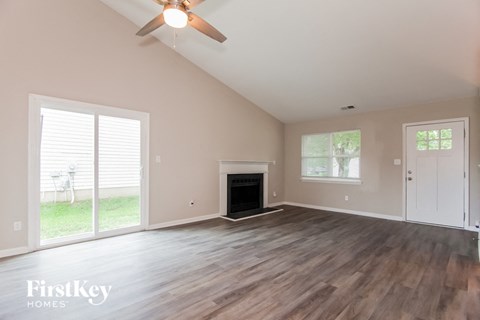 A spacious room with a fireplace and sliding glass doors.
