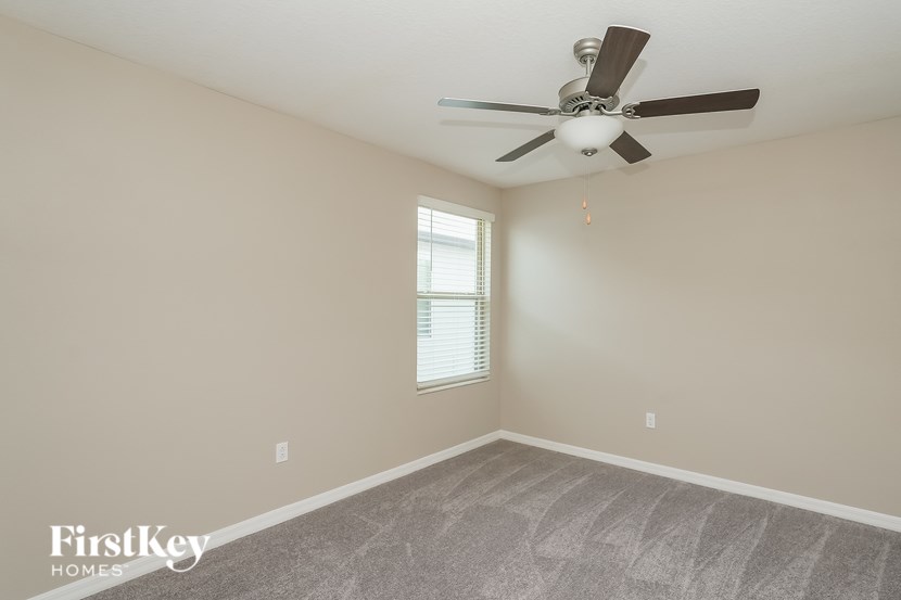 A room with a fan and a window.