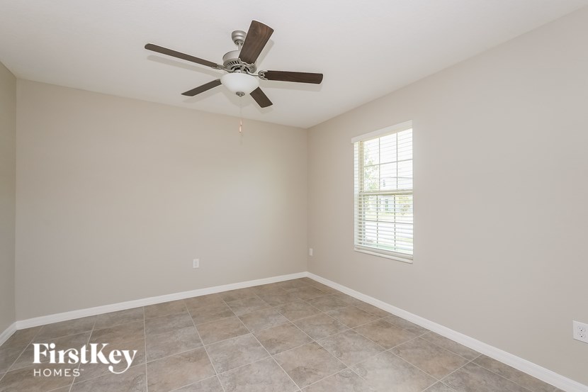 A room with a ceiling fan and a window.