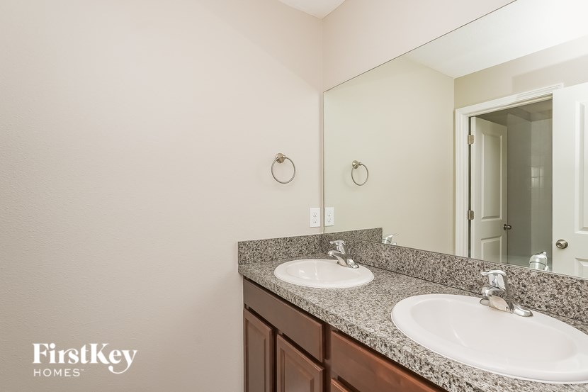 A bathroom with two sinks and a mirror.