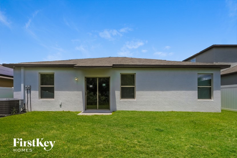 A house with a grey roof and a green lawn in front.