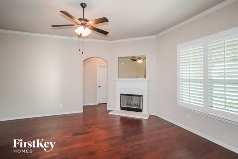 a living room with a fireplace and a ceiling fan