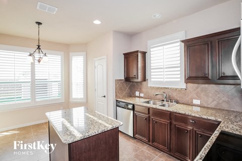 a kitchen with wooden cabinets and granite counter tops
