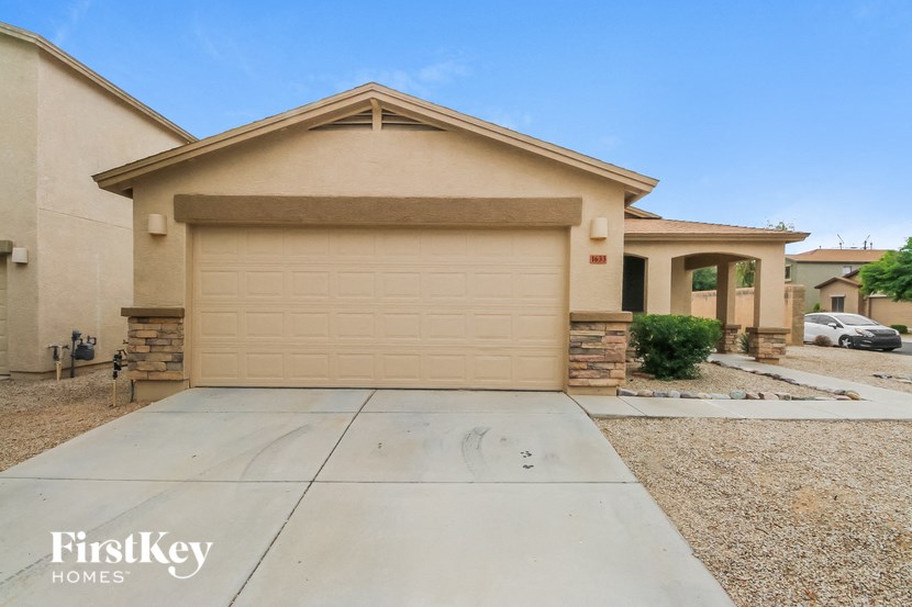 a beige house with a garage door and a driveway