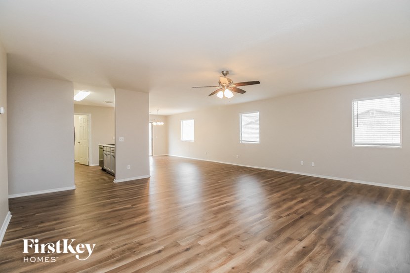 the living room and dining room with hardwood flooring and a ceiling fan