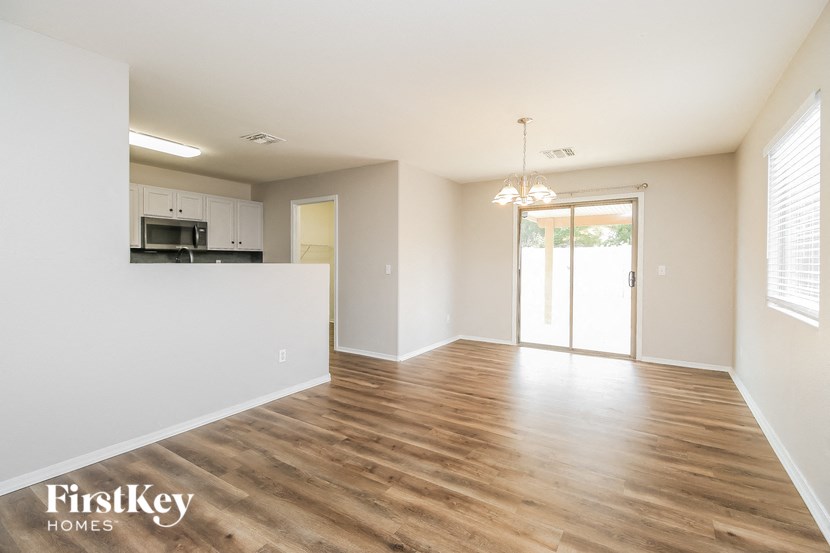 the living room and kitchen of an apartment with wood flooring