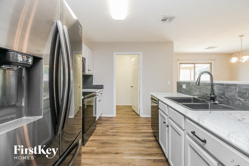 a kitchen with white cabinets and stainless steel appliances