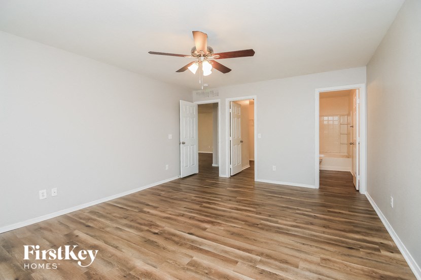a living room with white walls and a ceiling fan