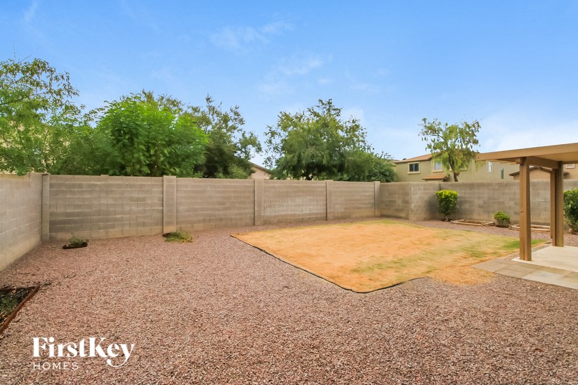 a backyard with gravel and a fence and a house
