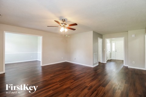 the living room and dining room with hardwood flooring and a ceiling fan