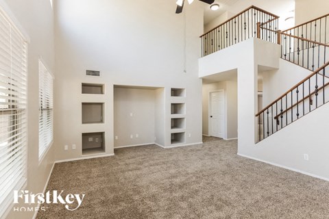 A spacious living area with a staircase and a fireplace.