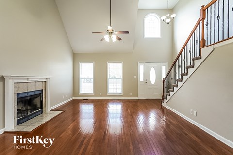 A spacious living room with wood floors and a fireplace.