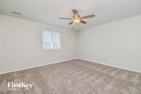 a living room with carpet and a ceiling fan