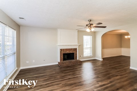 A spacious living room with a fireplace and hardwood floors.
