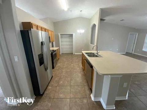 A kitchen with a black fridge and a white counter top.