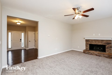a living room with a fireplace and a ceiling fan