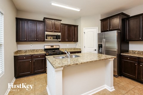 a kitchen with granite counter tops and dark wood cabinets