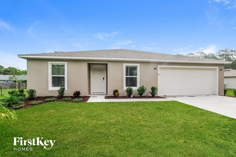 a beige house with a lawn and a garage door