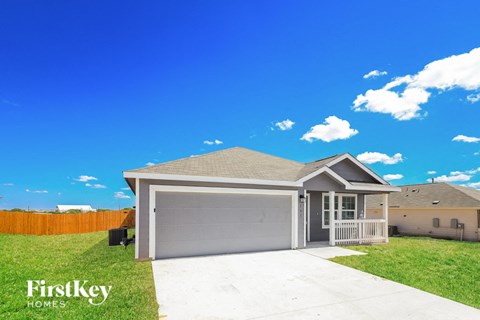 A house with a garage and a fence in the background.