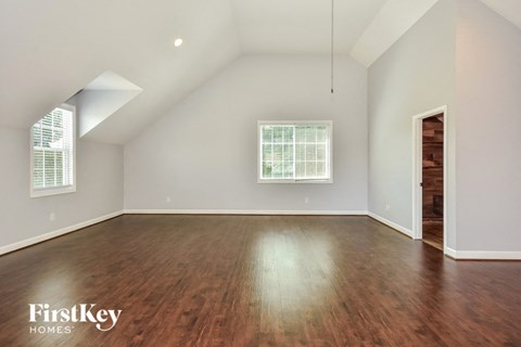 the living room with hardwood floors and a vaulted ceiling