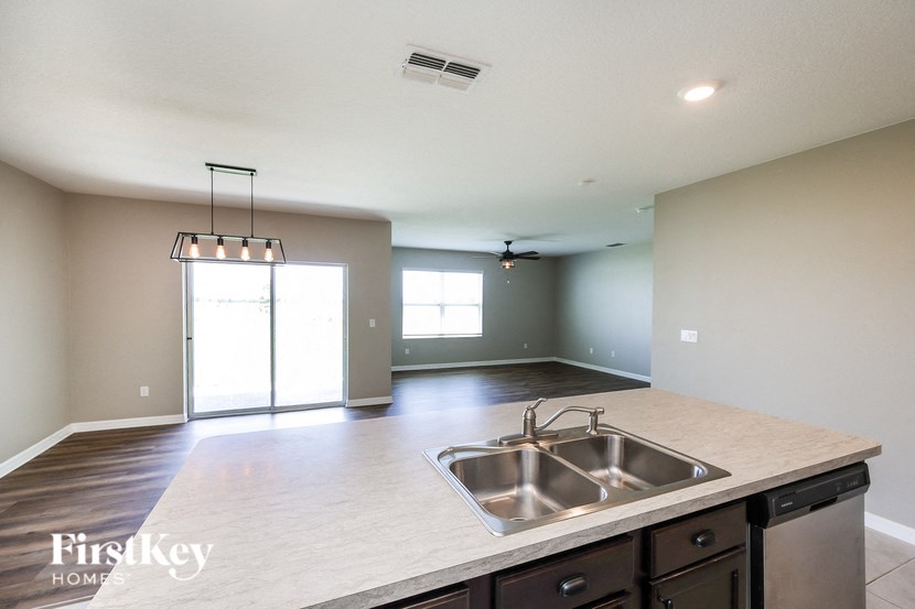 a kitchen with a sink and an empty living room