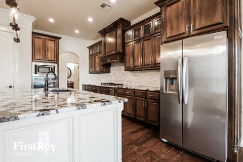 a kitchen with wooden cabinets and stainless steel refrigerator