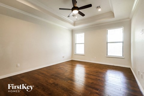 a living room with wood floors and a ceiling fan