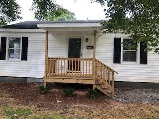 a small white house with a wooden porch