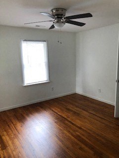 an empty room with a ceiling fan and a window