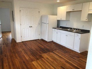 a kitchen with white cabinets and a wooden floor