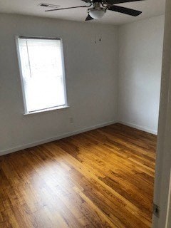 an empty room with a ceiling fan and a window