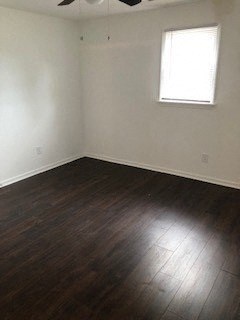 an empty room with wooden floors and a window