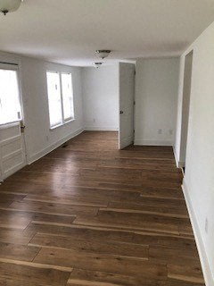 a living room with wooden floors and white walls