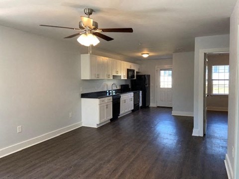A kitchen with white cabinets and black appliances.