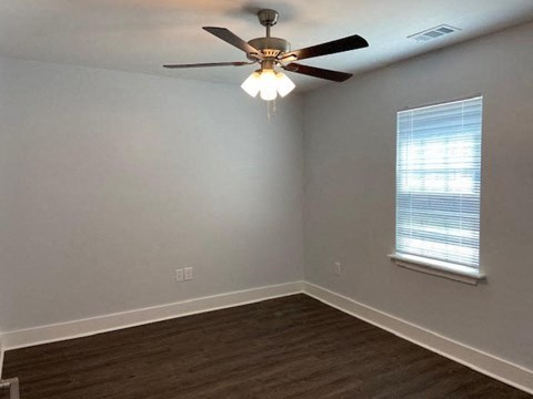 A room with a ceiling fan and a window.
